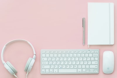 white apple magic mouse beside of magic keyboard and headphones flat teams background