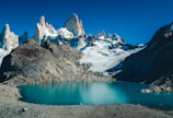 snow covered mountain beside body of water