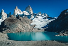 snow covered mountain beside body of water