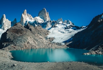 snow covered mountain beside body of water