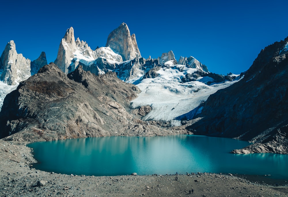 montagna coperta di neve accanto allo specchio d'acqua