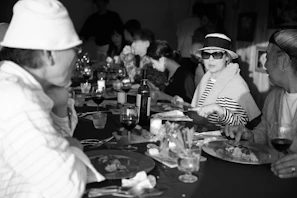 A small group of guests sharing stories and laughter around an intimate supper table.
