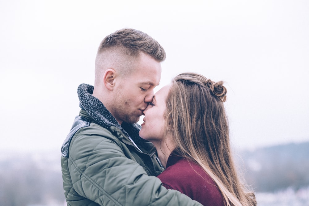 man kissing woman