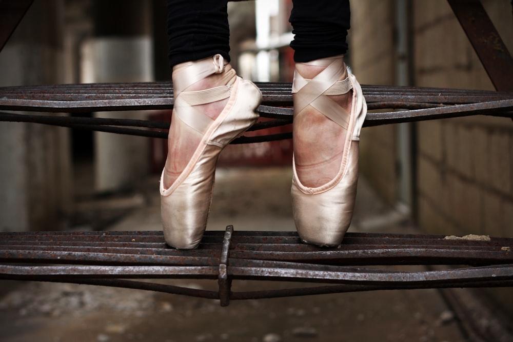 Une femme debout sur la pointe des pieds dans des chaussures de danse dans un escalier extérieur.