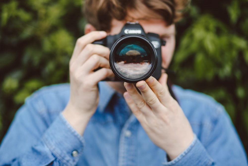 persona sosteniendo una cámara DSLR