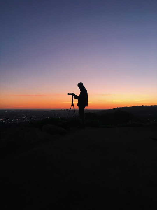 silhouette of man in front of DSLR camera during golden hour in Griffith Observatory United States
