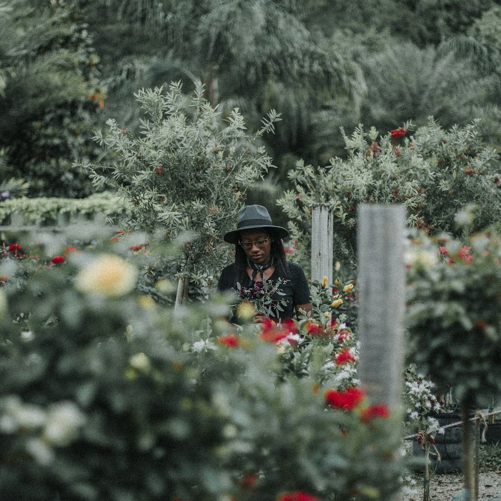 woman in black hat standing on garden