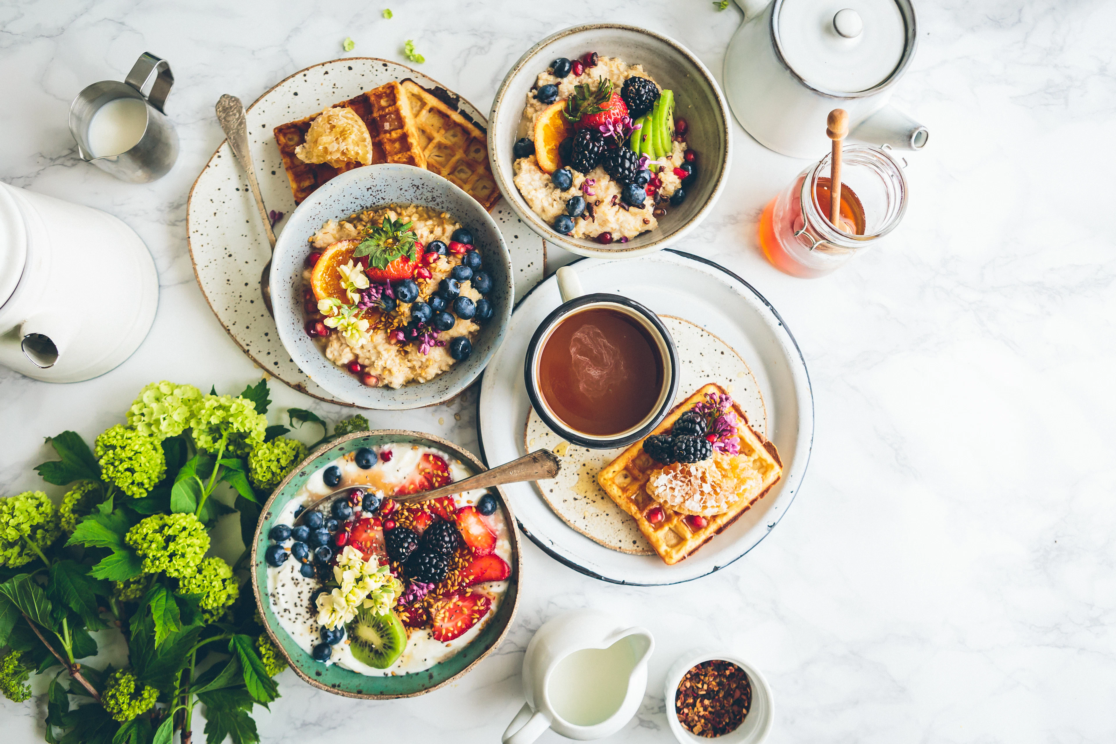 A bright breakfast flatlay of small plates, fruit and pastries