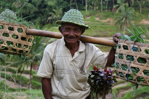 Suhartono interacting warmly with local farmers in a village.