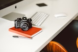 black Nikon DSLR camera on red notepad