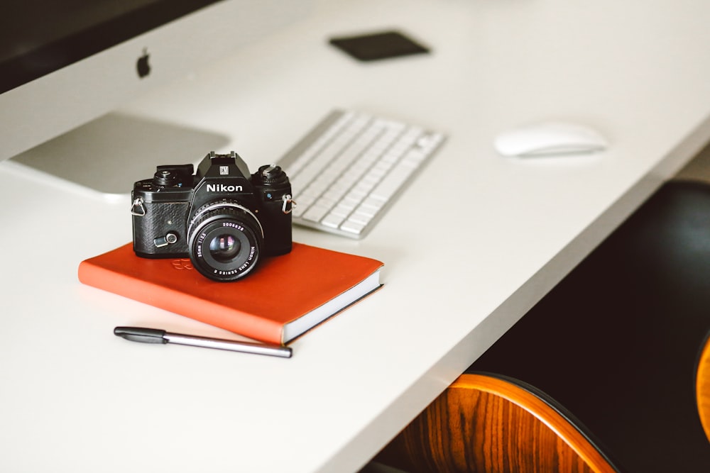 black Nikon DSLR camera on red notepad