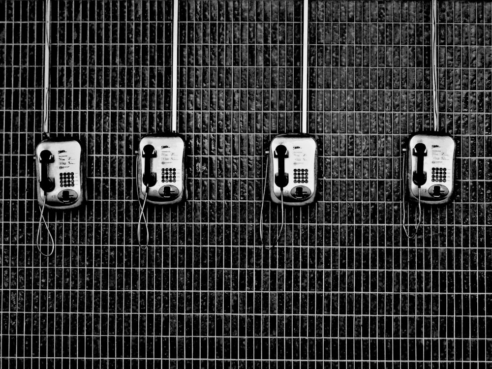 four black-and-grey telephones