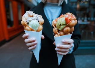 person holding two ice creams