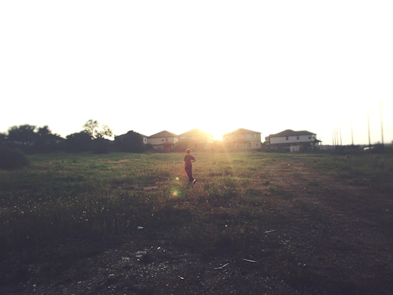 A spacious 600 sq.ft plot with open land and a sunset casting warm light over the area.