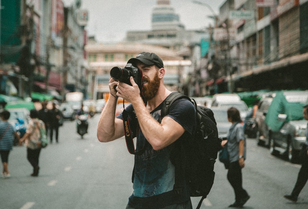 Flachfokusfotografie eines Mannes mit einer DSLR-Kamera