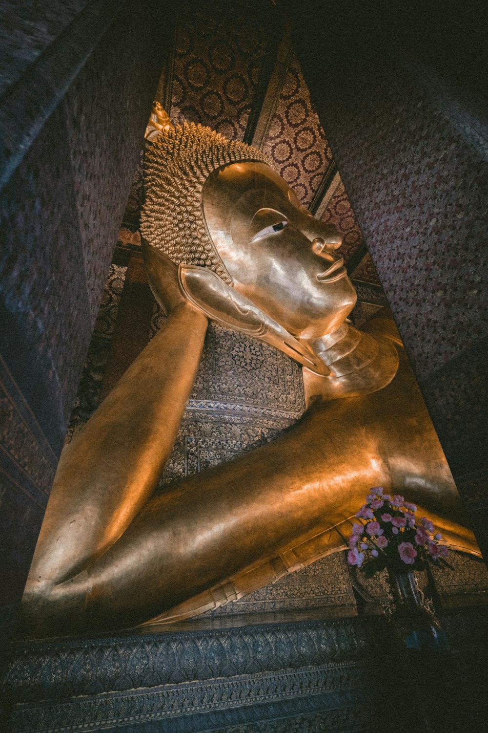 a large golden statue of a person laying down