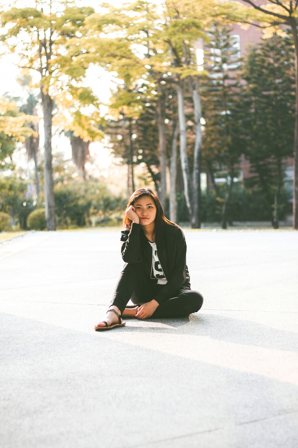 woman in black jacket while sitting on floor