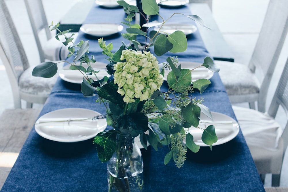 Tafelaufsatz mit grüner und weißer Blume auf dem Tisch