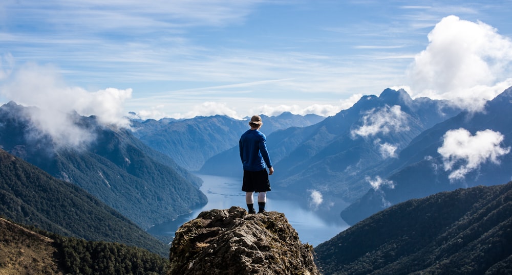 person standing on the top of high rise stone