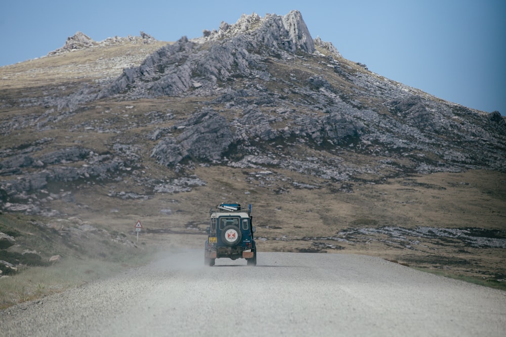 green Jeep on grey asphalt road