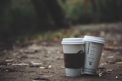 two white disposable cups place on brown soil togo zoom background