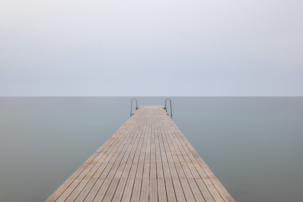 brown wooden dock with cloudy sky