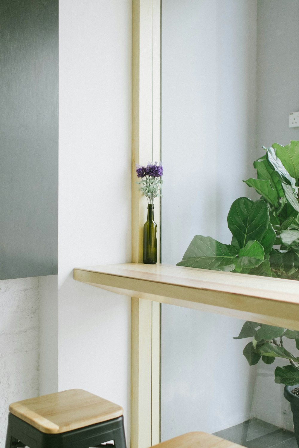 a wooden shelf with a vase of flowers on top of it