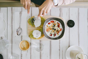 a person cutting up food on a cutting board