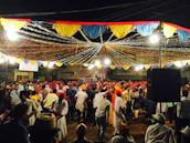 A community celebration with diverse people dancing and smiling under colorful decorations.