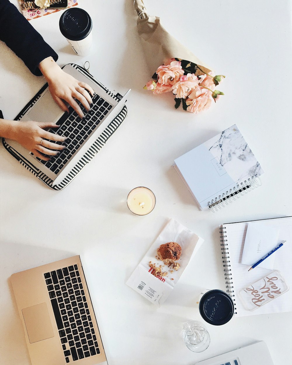 A flatlay image of a person typing on keyboard.