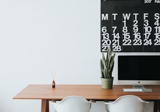 silver iMac on brown wooden desk