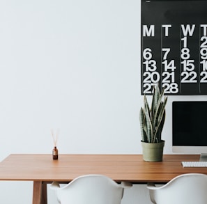 silver iMac on brown wooden desk