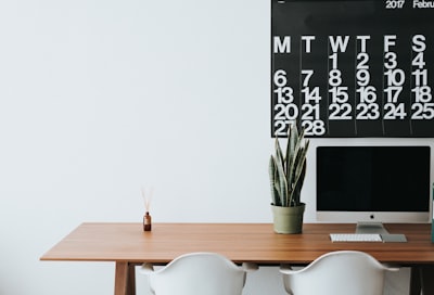 silver imac on brown wooden desk workspace zoom background