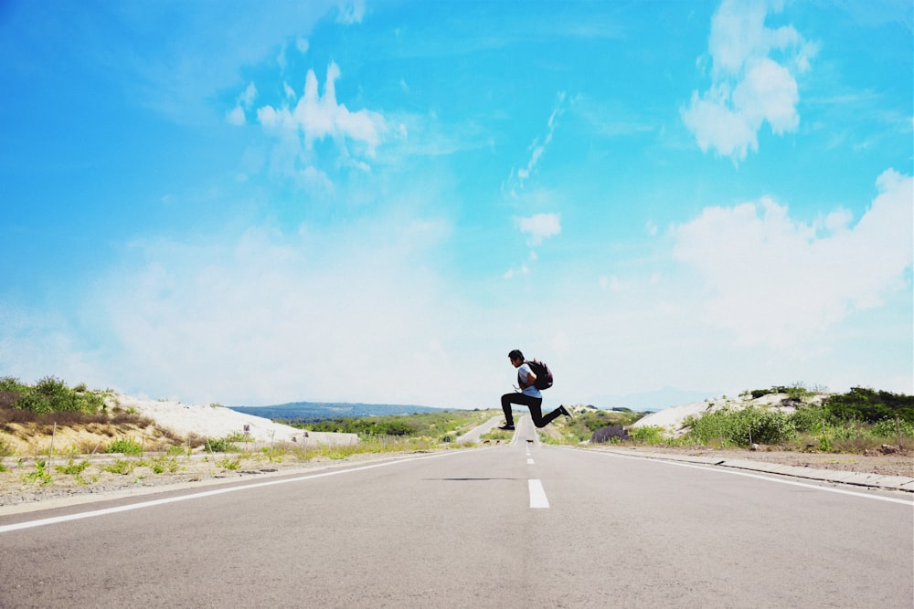 man jumping on street during daytime