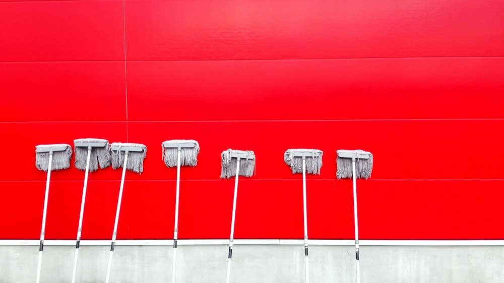 seven white push mops on wall