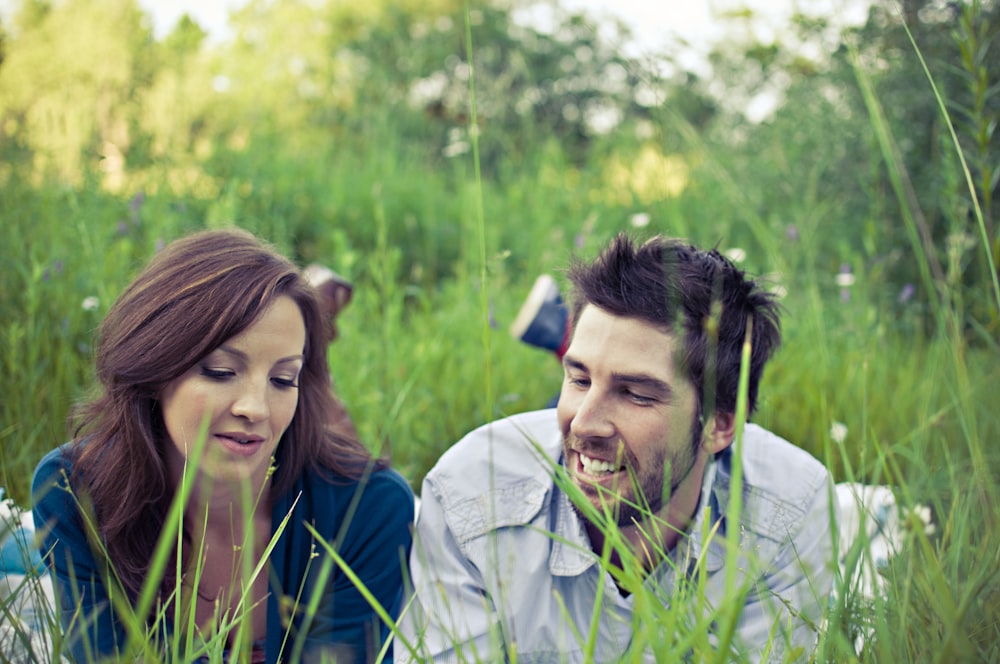 man and woman lying on the grass