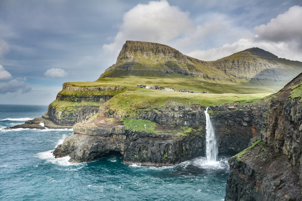 waterfalls on mountain under nimbus clouds