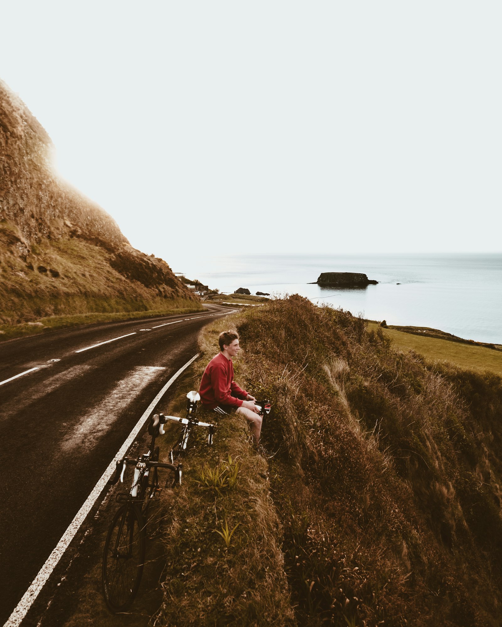 A group of cyclists riding down a curvy mountain road during a long group ride