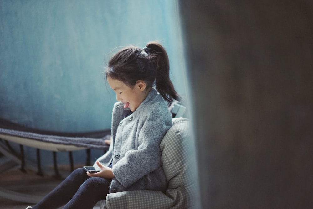 girl sticking her tongue out while using mobile phone