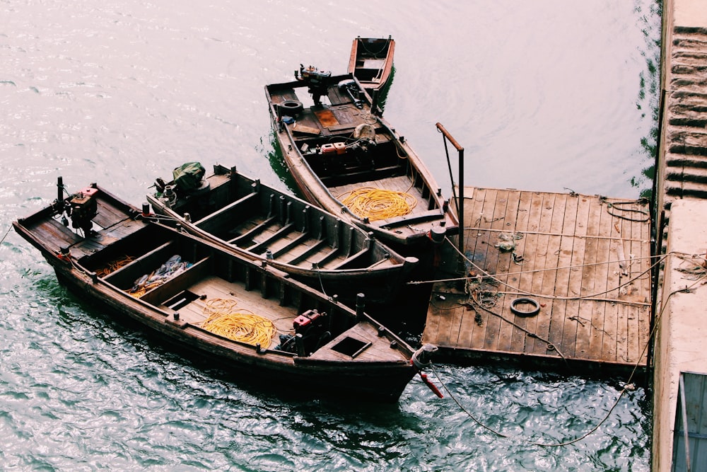 três barcos amarrados no cais