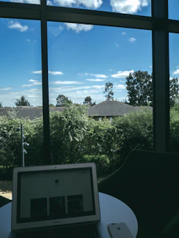 A calm morning scene with a planner, glasses, and a fresh blue sky visible through a window.