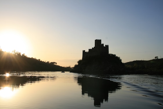 A serene view of Spøttrup Castle surrounded by its moat under a soft sunset sky.