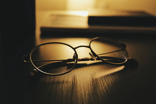 Round eyeglasses resting on a desk