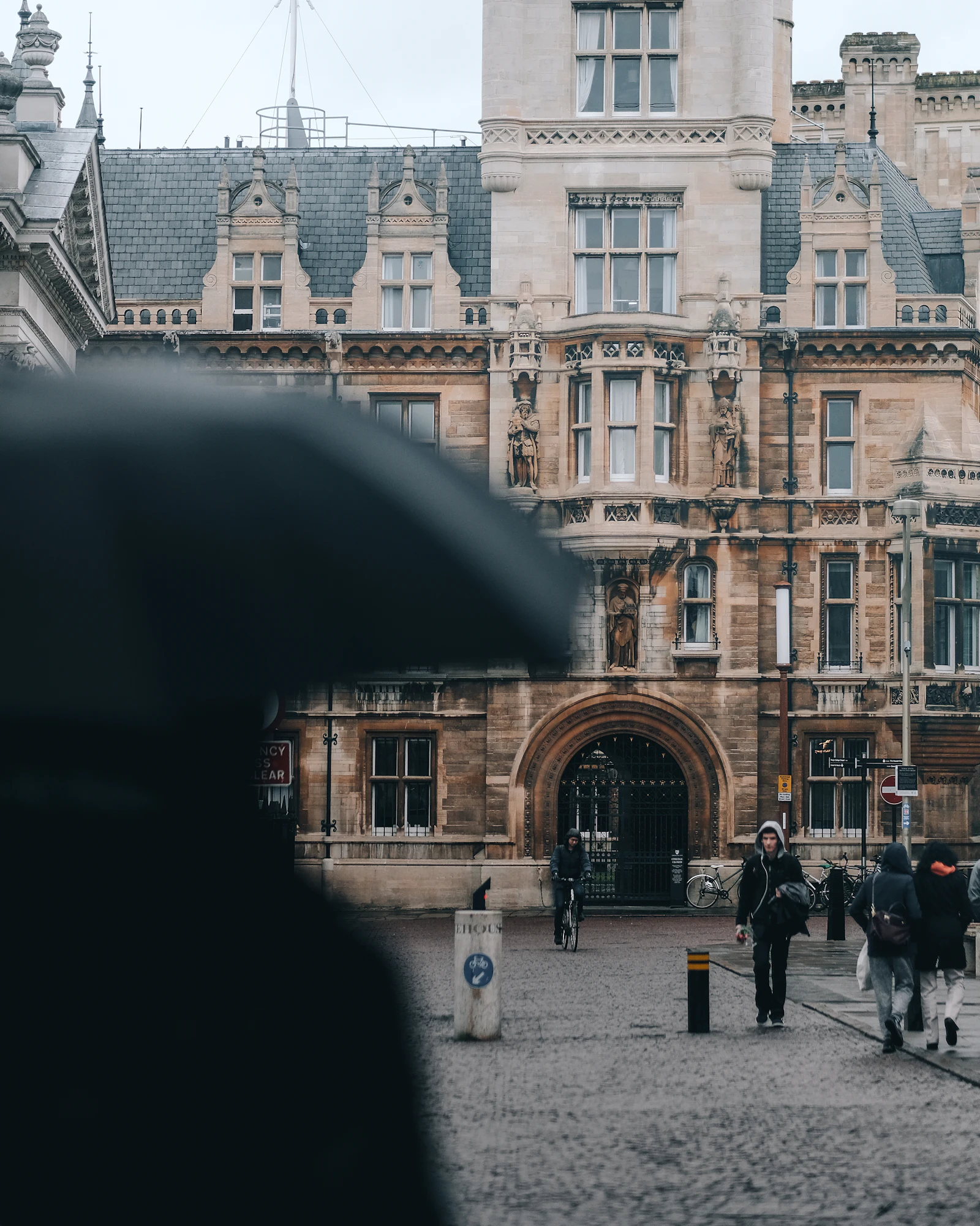 A rainy day on King's Parade, with a man walking under an umbrella