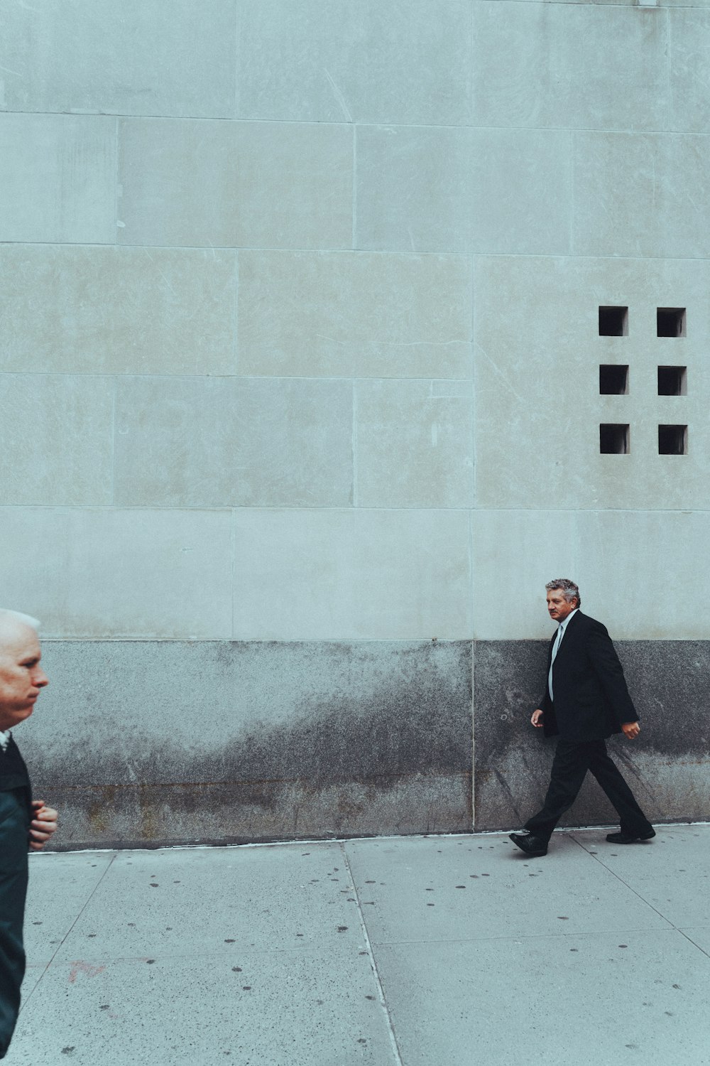 two man walking near building