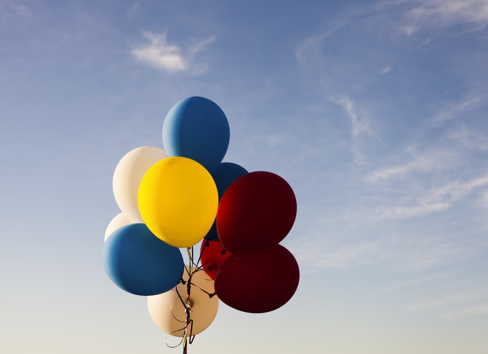 white, yellow, red, and blue balloons under blue sky