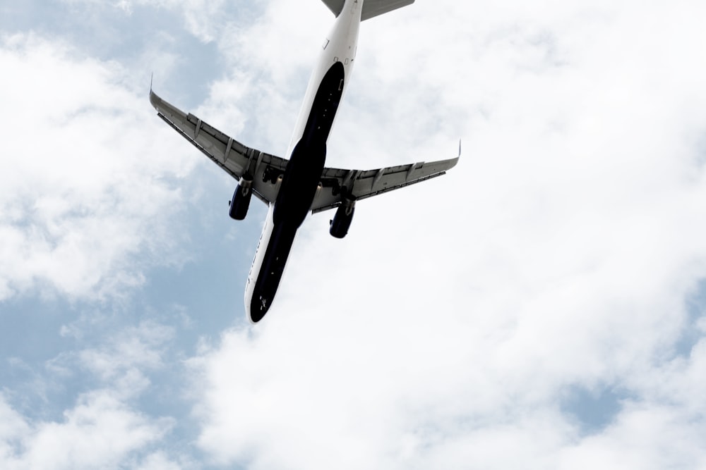 white air plane under the clouds