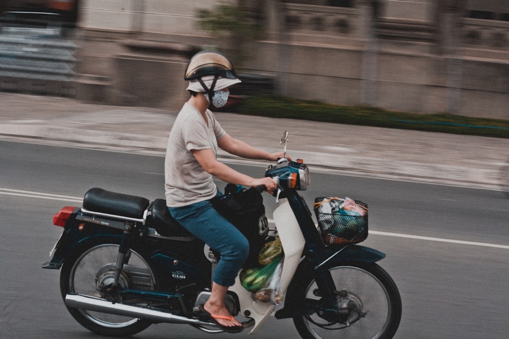 man riding black and white motor scooter