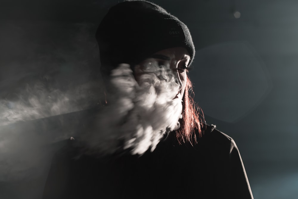 fotografía de retrato de persona soplando humo