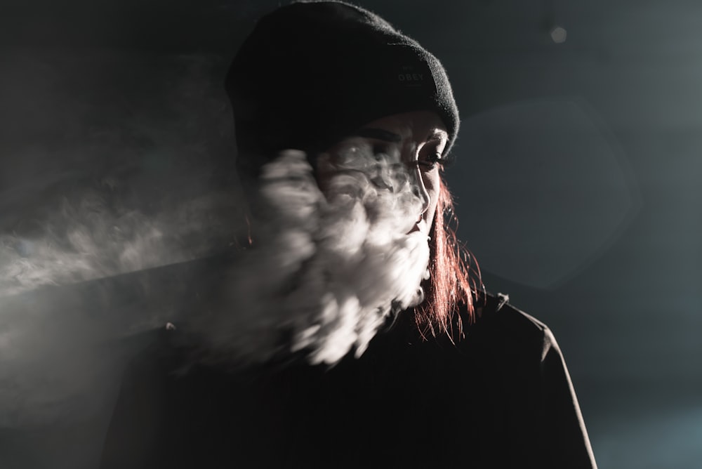 Porträtfotografie einer Person, die Rauch bläst